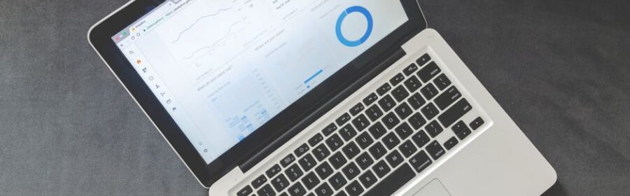 Overhead view of a laptop showing data visualizations and charts on its screen.